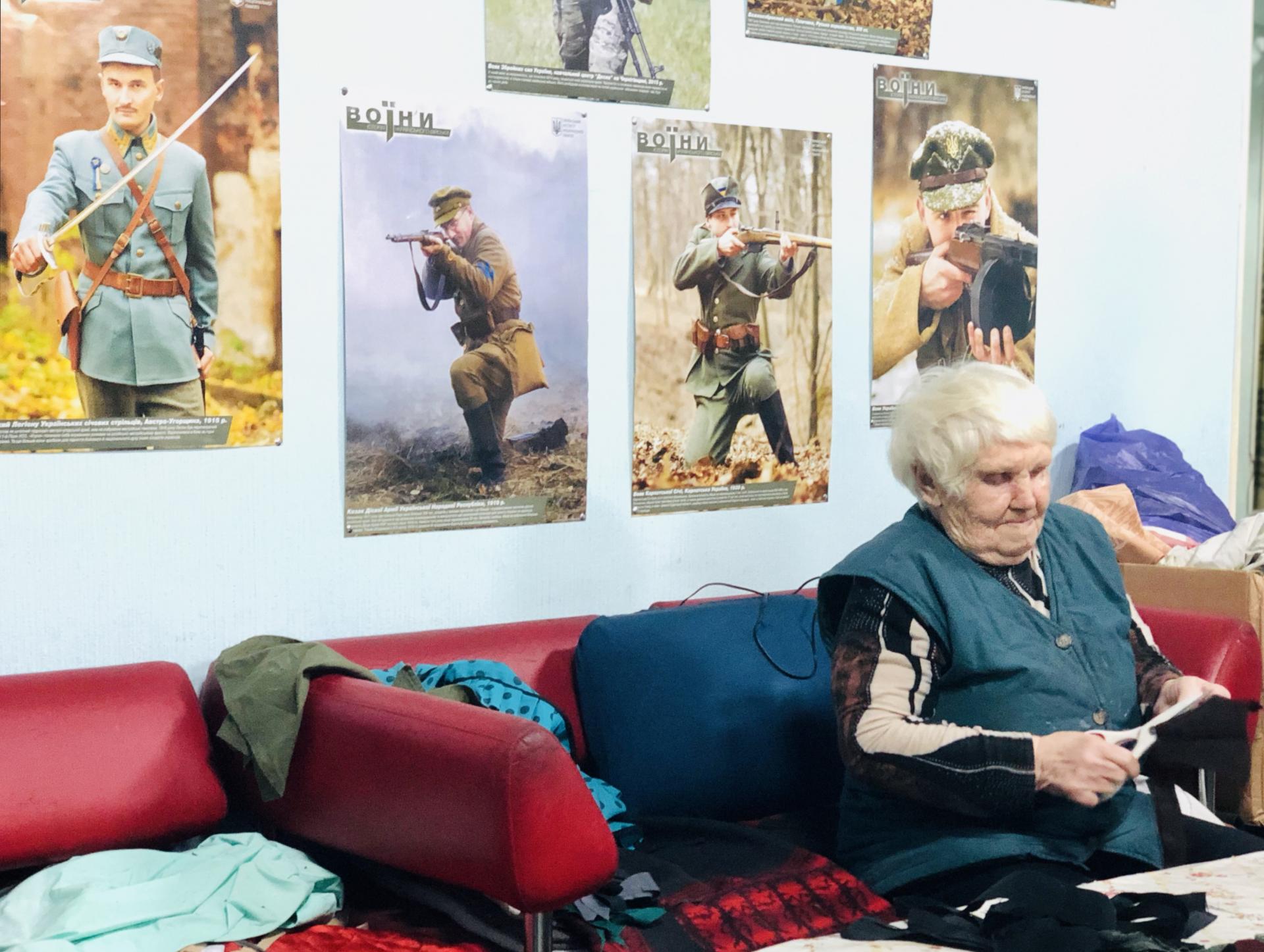 Staršia dobrovoľníčka z Kramatorska, ktorá je členkou organizácie Kramatorské včely, strihá kusy látky určené na výrobu maskovacích sietí pre ukrajinských vojakov.