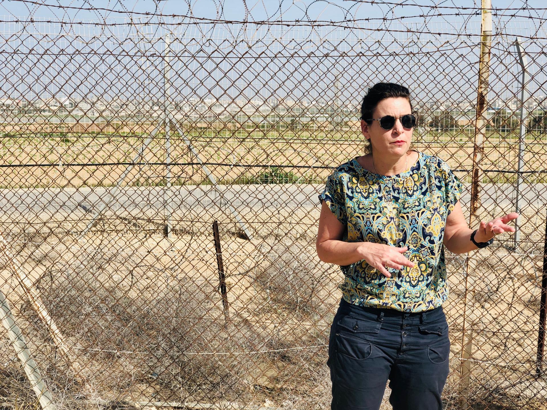 Yael Raz Lachyani, hovorkyňa a jedna z obyvateliek Nachal Oz, stojí pri plote, ktorý ohraničuje celý kibuc.