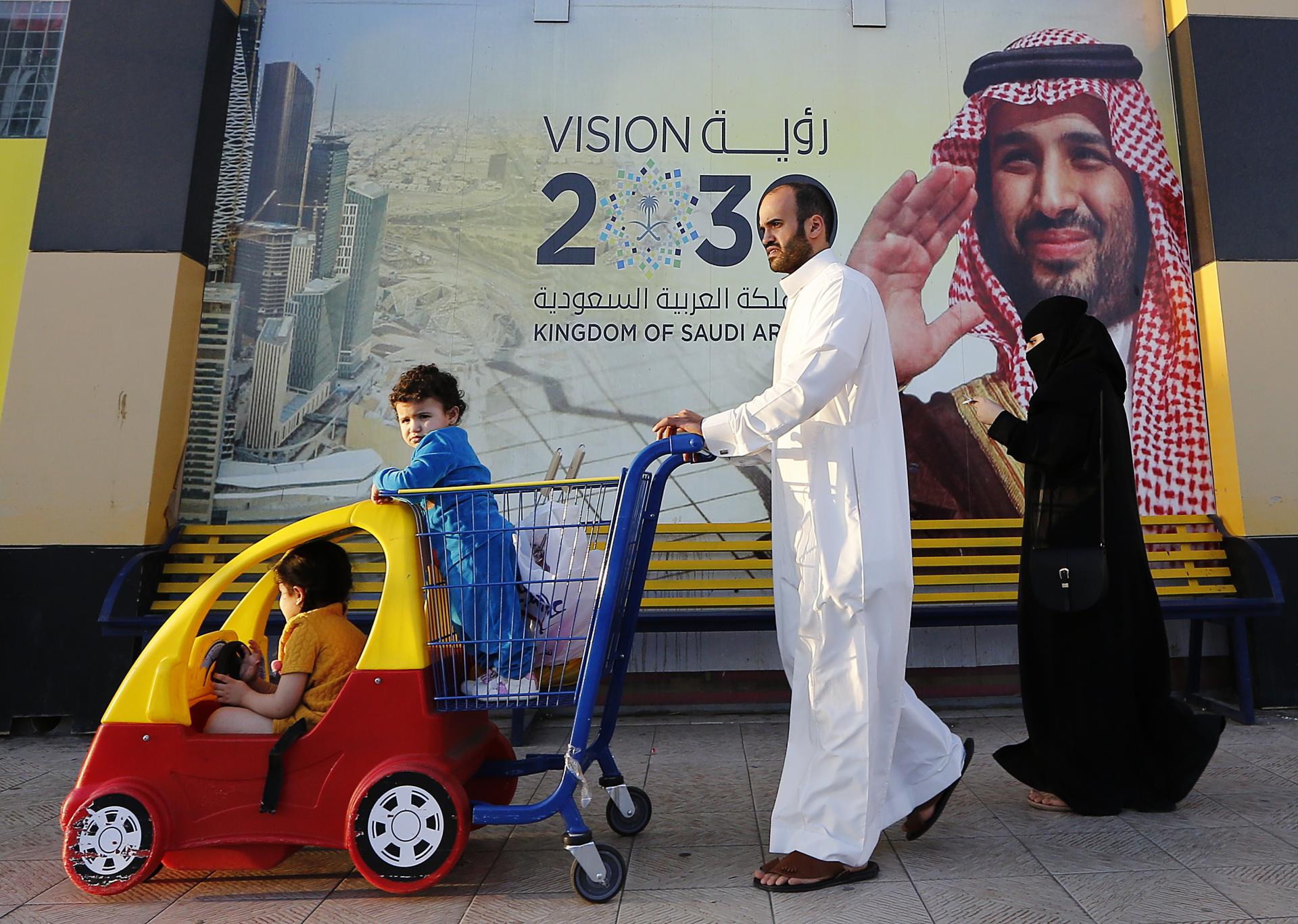 5. február 2020 Džidda, Saudská Arábia: Rodina kráča popri transparente s fotografiou saudskoarabského korunného princa Mohameda bin Salmána. Špeciálny protiteroristický súd v krajine trestá aj disidentov či kritikov režimu.