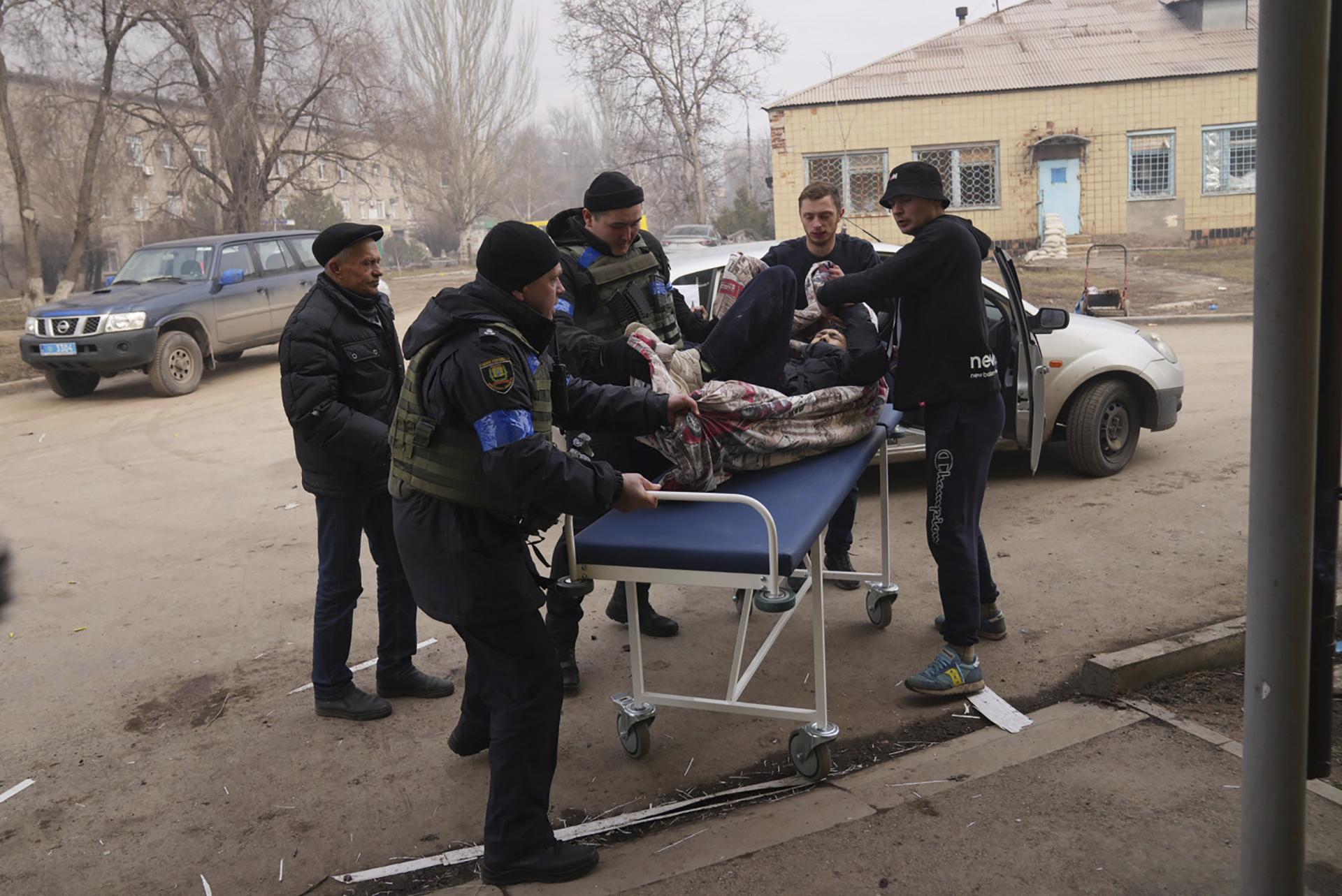 Ukrajinskí vojaci a dobrovoľníci prevážajú muža zraneného počas ostreľovania do nemocnice číslo 3 v Mariupole na Ukrajine v utorok 15. marca 2022
