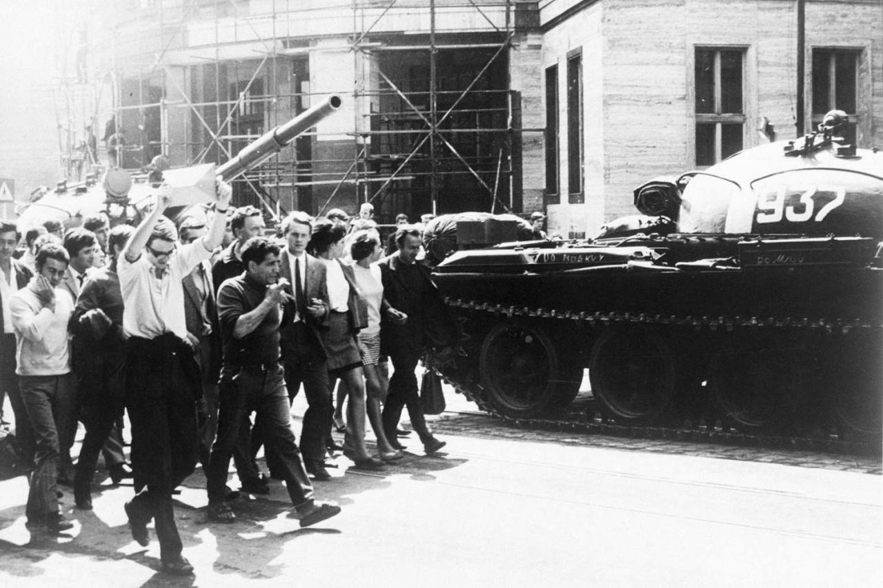 23. august 1968, Bratislava: Mladí demonštranti prechádzajú okolo rozostavených sovietskych tankov pred budovou Univerzity Komenského.