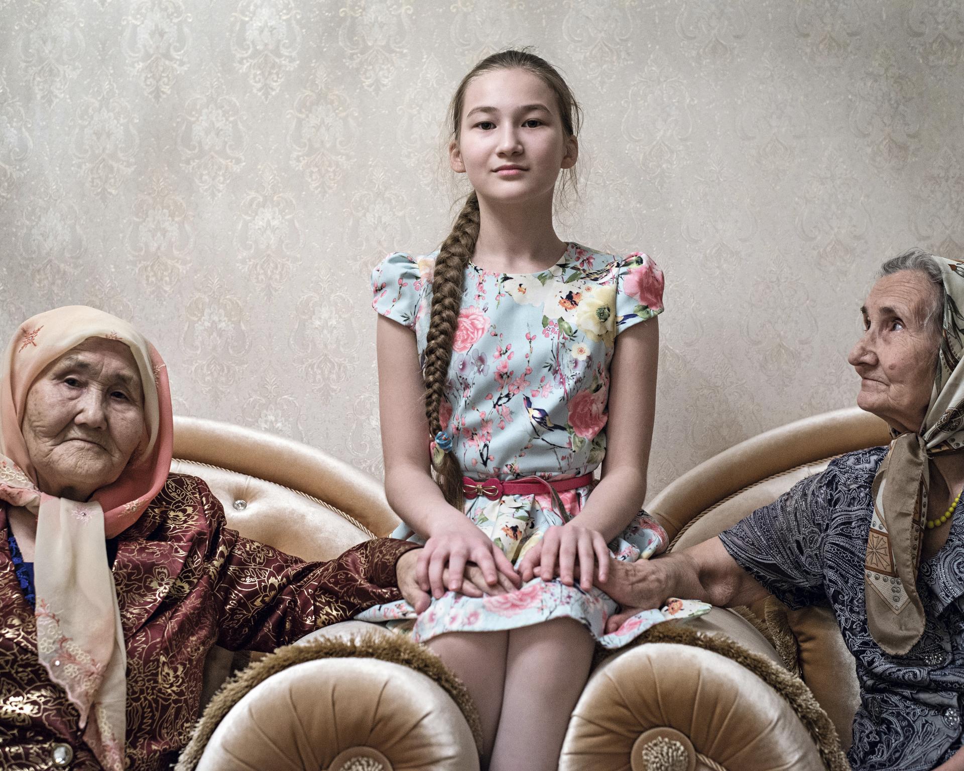 Tomiris (10 r.) sediac medzi dvoma starými mamami, jednou z Ruska a druhou z Kazachstanu, Tomiris hovorí plynulo oboma jazykmi, 2020.