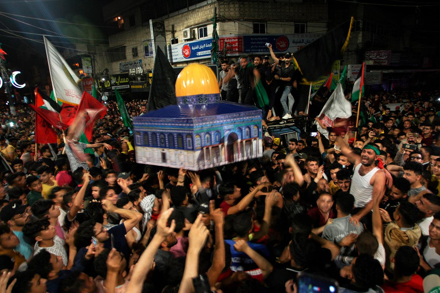 20. máj 2021 Gaza: Palestínčania oslavujú prímerie, na rukách nesú model jeruzalemskej mešity al-Aksá.