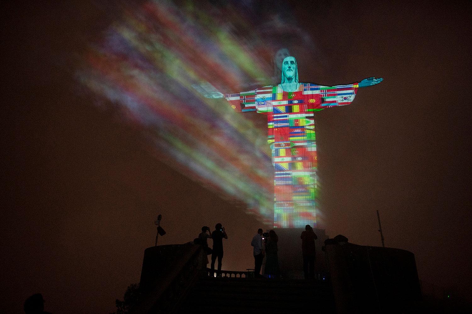 18. marec 2020 Rio de Janeiro, Brazília: Najznámejší brazílsky symbol kresťanstva, slávnu sochu Krista Spasiteľa na pahorku Corcovado, vysvietili do farieb vlajok krajín postihnutých pandémiou koronavírusu.