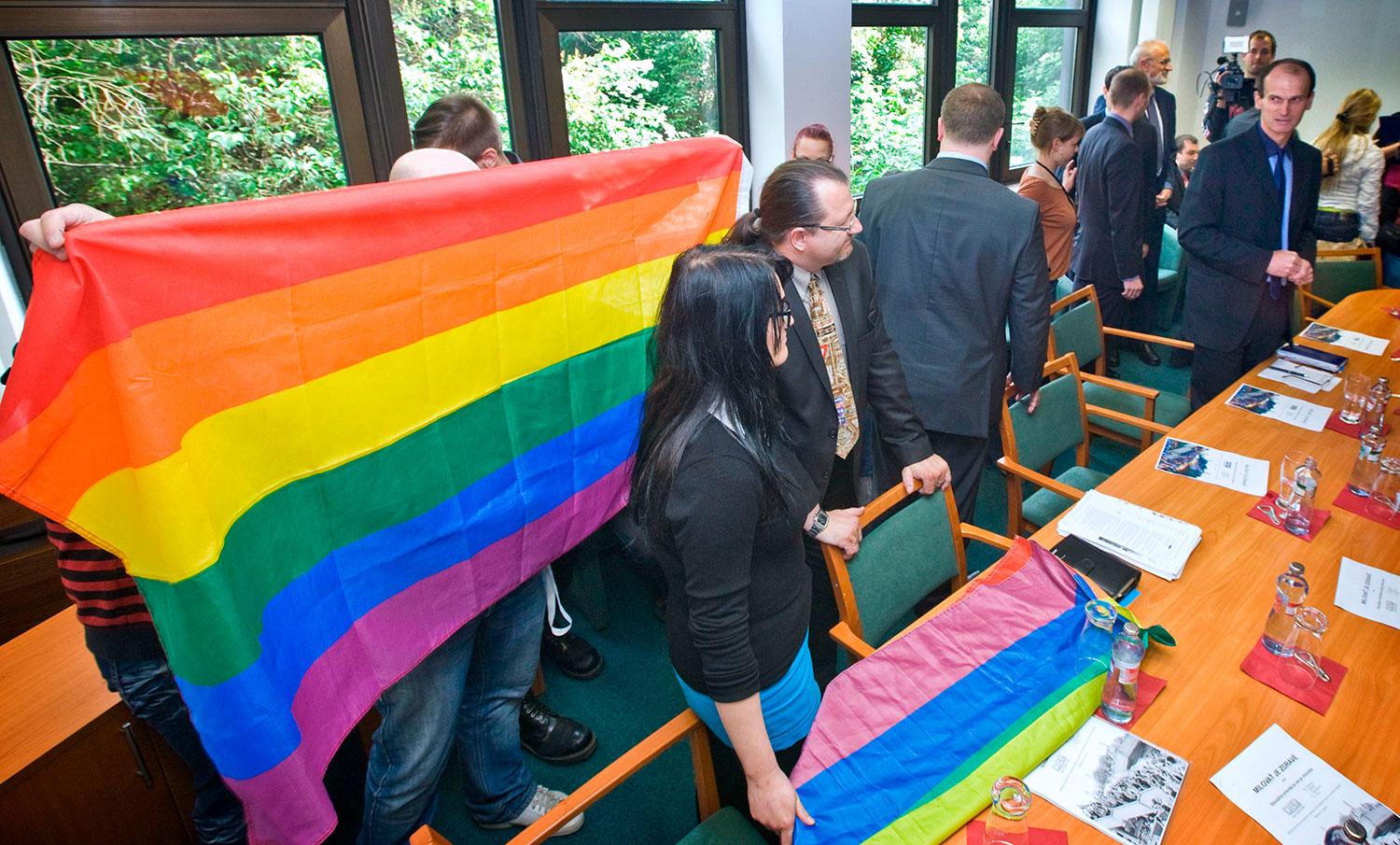 16. máj 2012 Bratislava: Predstavitelia Dúhového PRIDE Bratislava navštívili parlament a stretli sa s poslancami z klubu OĽaNO. Ľudskoprávna aktivistka Romana Schlesinger kladie na stôl dúhovú vlajku pred zrakmi Branislava Škripeka a Štefana Kuffu.