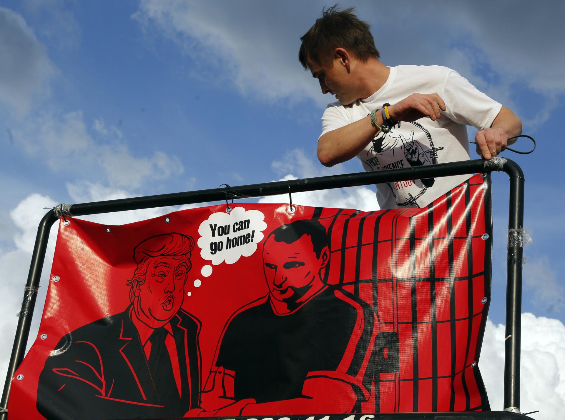 Ukrajina: Aktivista upravuje plagát na podporu Olega Sencova.