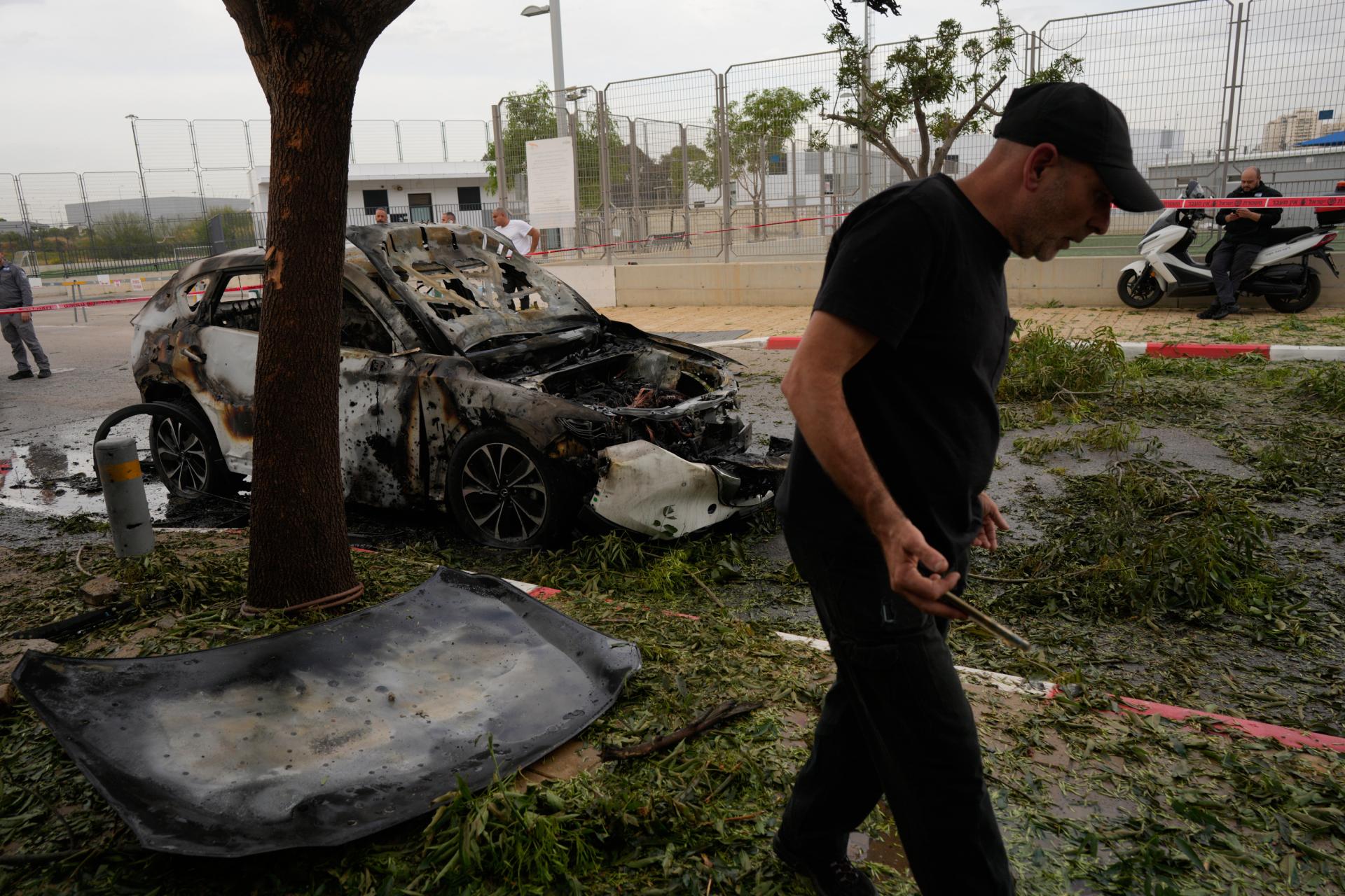 Muž skúma miesto iránskeho raketového útoku v meste Petah Tikva v Izraeli, 18. 3. 2026.