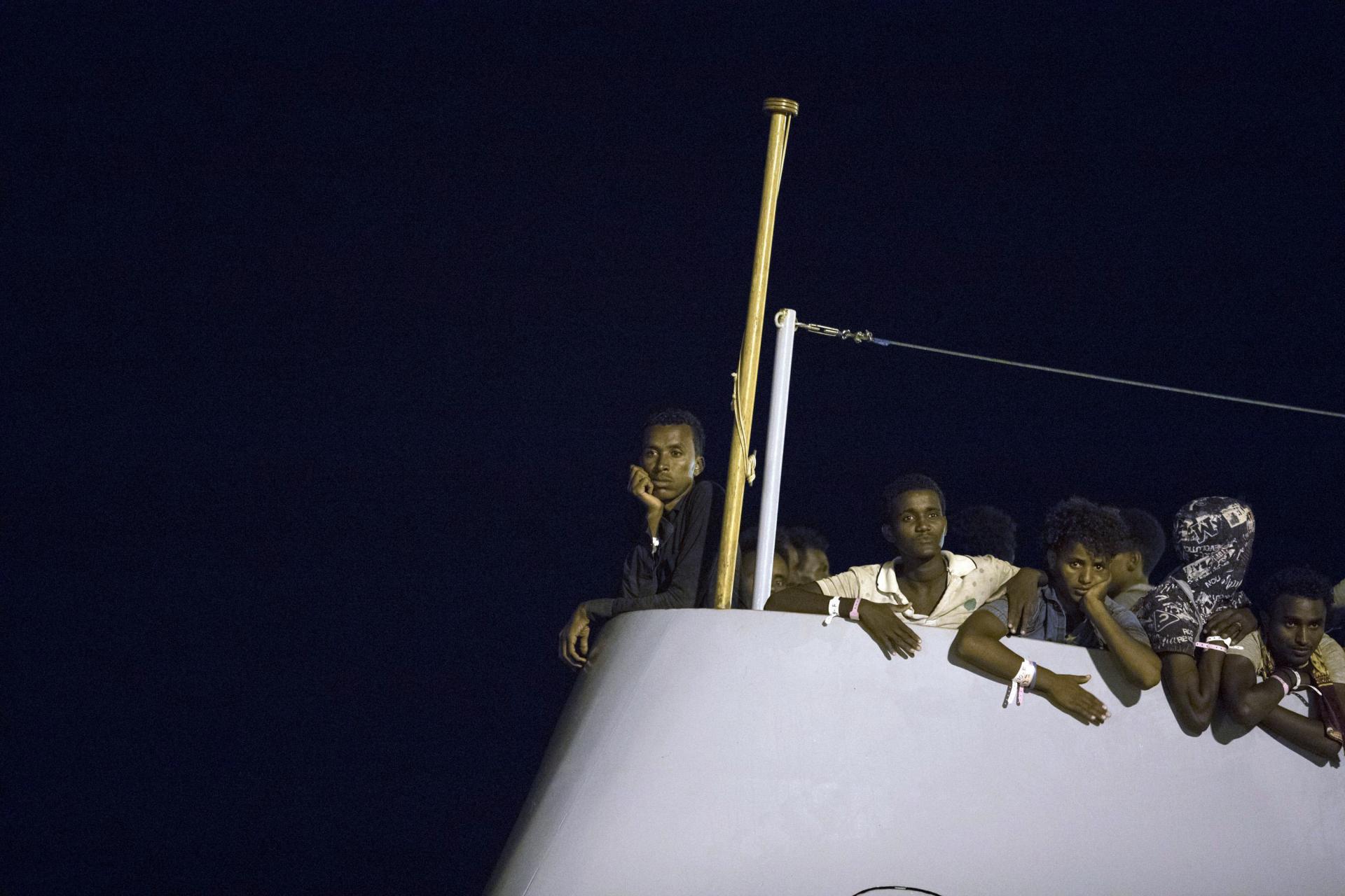 16. júl 2018 Taliansko: Migranti čakajú na vylodenie z lode Frontex Protector v prístave Pozzallo v skorých ranných hodinách.