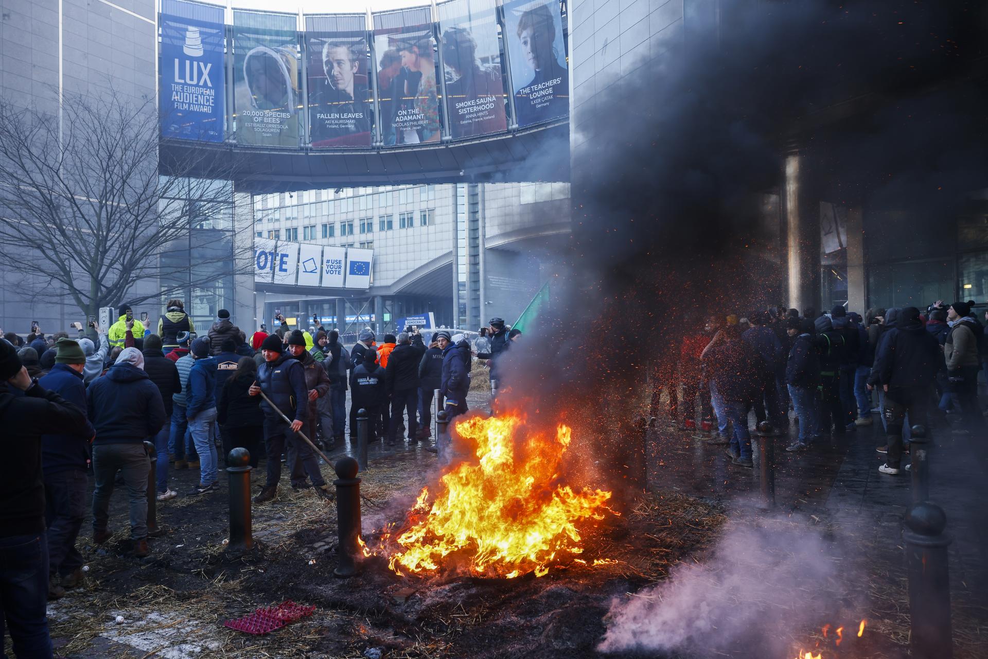 Farmári pália slamu a pneumatiky počas protestu pred Európskym parlamentom. Brusel, 1. 2. 2024