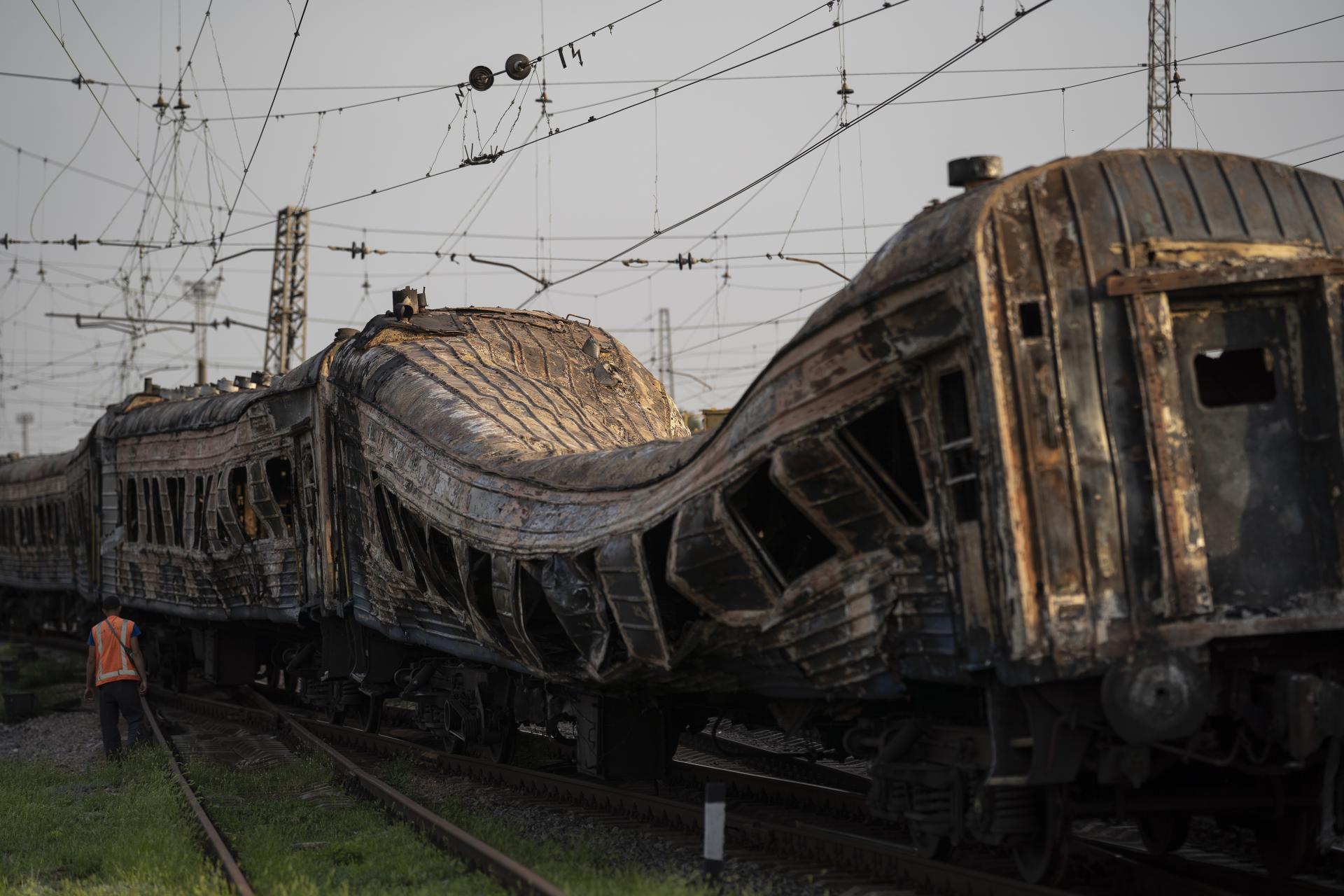 Železničný pracovník stojí vedľa ťažko poškodeného vlaku po ruskom útoku na železničnú stanicu počas Dňa nezávislosti Ukrajiny