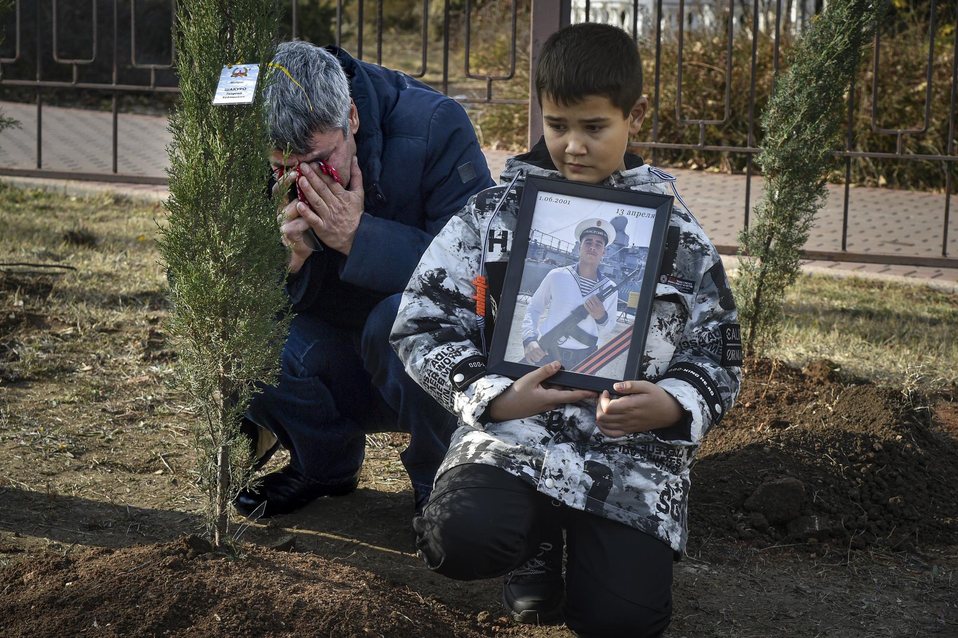 Chlapec drží fotografiu ruského námorníka Georgija Shakura, ktorý bol zabitý pri vojenskej akcii na Ukrajine. Sevastopol, Krym, nedeľa 20. novembra 2022