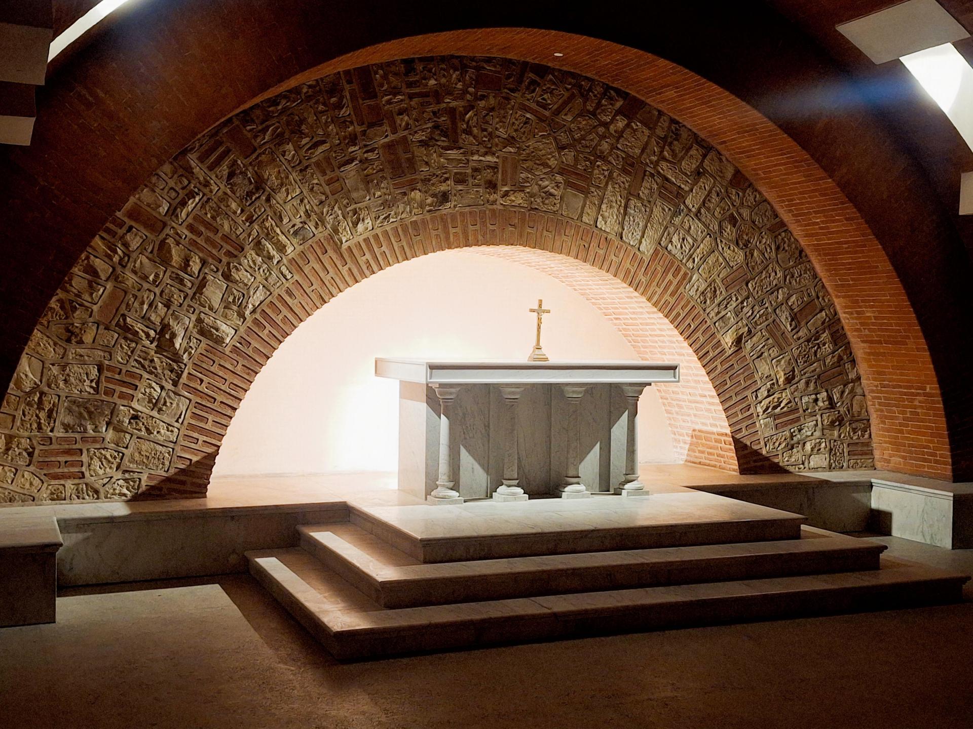 Podrzemná krypta kostola Najsvätejšieho srdca Pána je navrhnutá tak, aby vaša pozornosť po tehlových stenách nerušene skĺzla na moderný oltár oproti vám. Ten lemujú kamene privezené priamo z Pražského hradu.