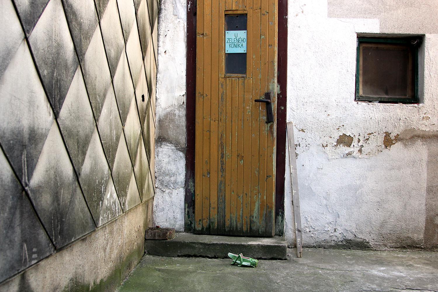 MATÚŠ ZAJACUlička od bránky ústi k dverám s nápisom U Zeleného koníka.
