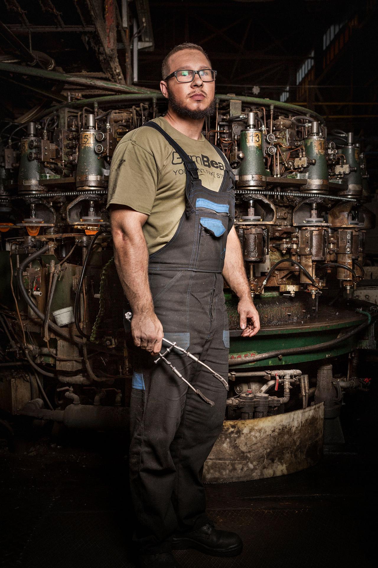 Ľubomír, 22 rokov, Málinec. Mladý strojník dozerá na to, aby zo sklárskeho stroja vychádzali bezchybné poháre.