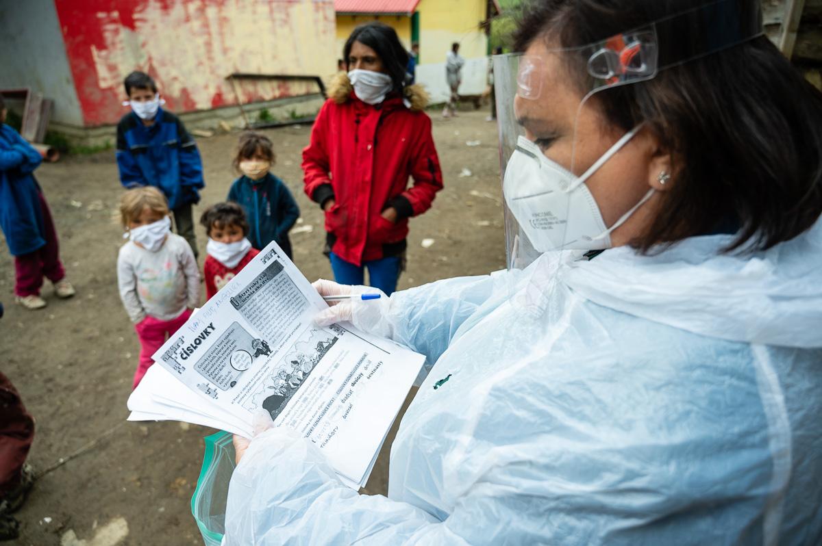  Pracovníčka Človek v ohrození, n.o. kontroluje pracovné listy od detí z miestnej vylúčenej komunity. 
