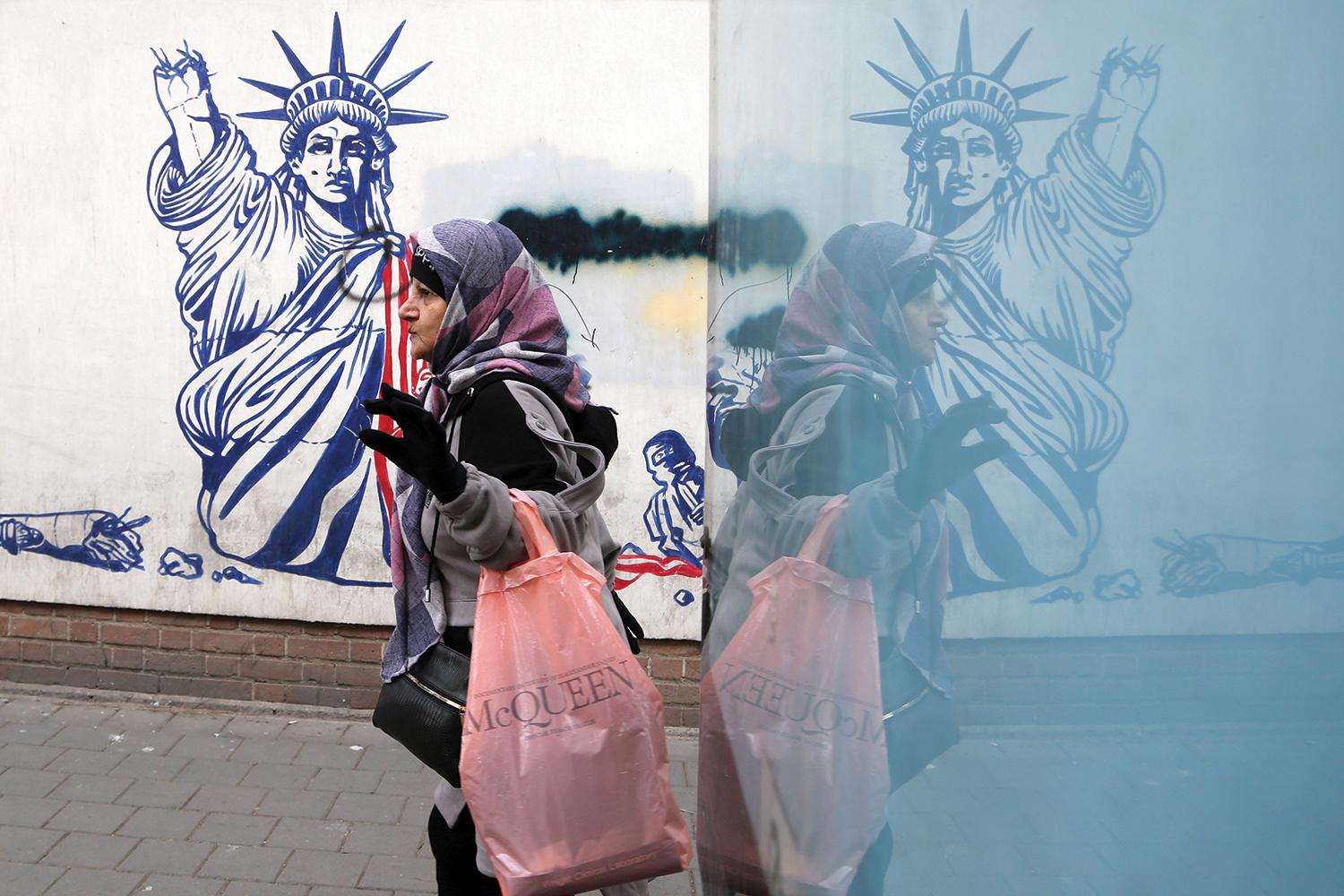 28. január 2025 Teherán, Irán: Obyvateľka mesta prechádza okolo antiamerického muralu.