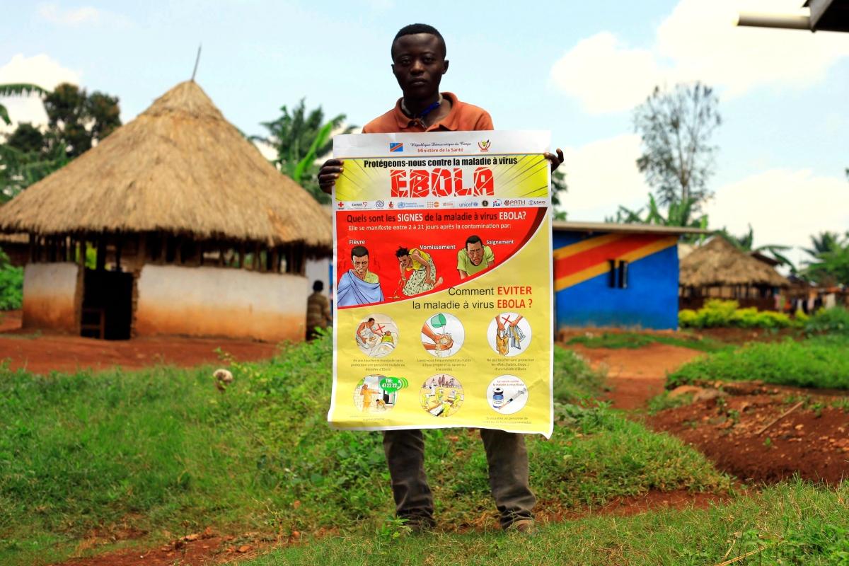 Muž v meste Mangina drží informačný plagát o ebole. Zdravotníci robia opatrenia v regióne, kde si vírus vyžiadal už 9 obetí.