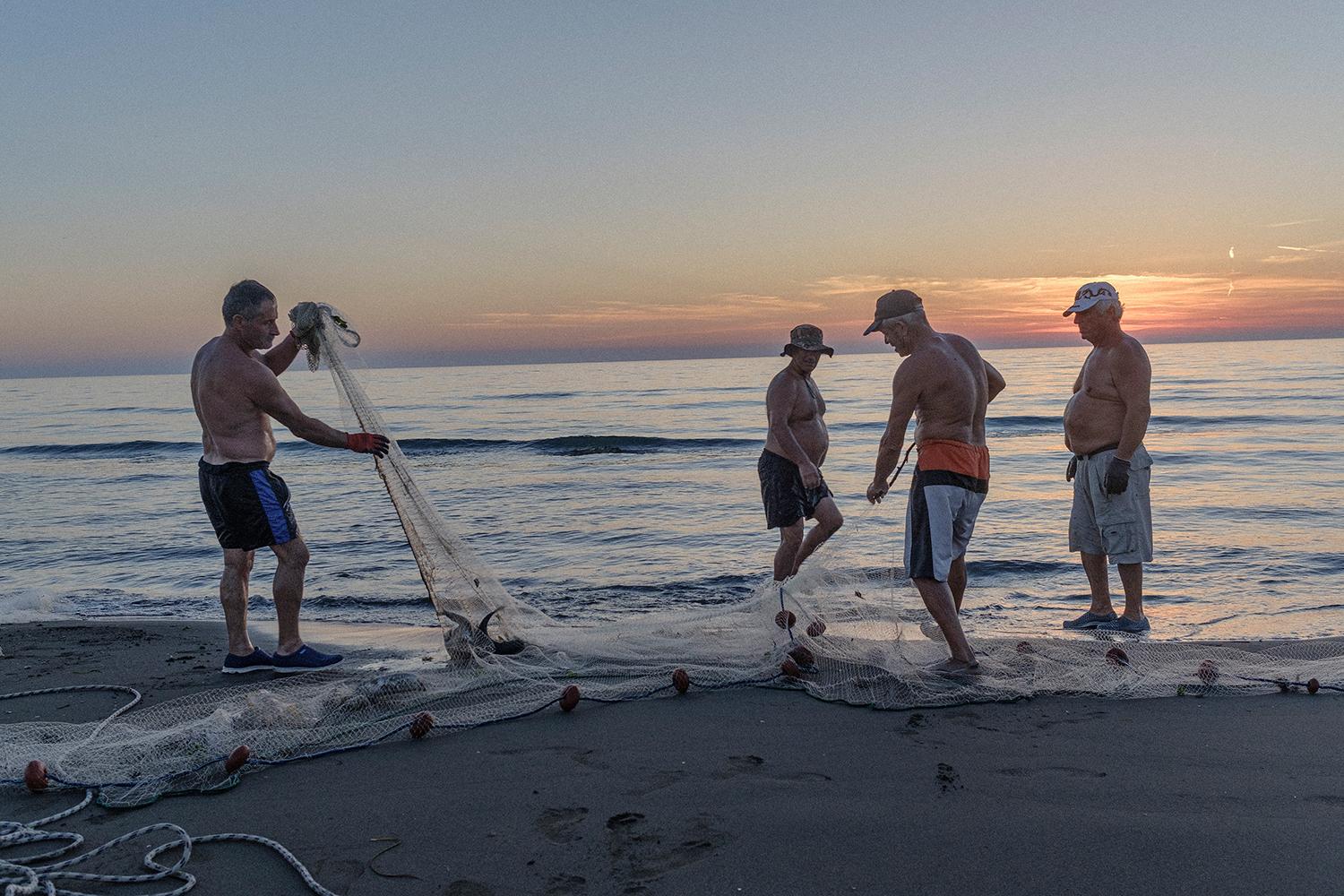 Večerný lov rýb na pláži pri meste Fier.
