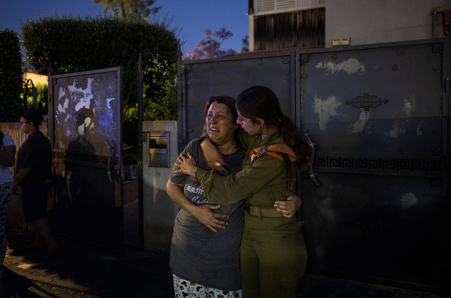12. máj 2021 Aškelon, Izrael: Izraelská vojačka utešuje ženu po tom, čo bol jej dom zničený po ostreľovaní Hamasom.