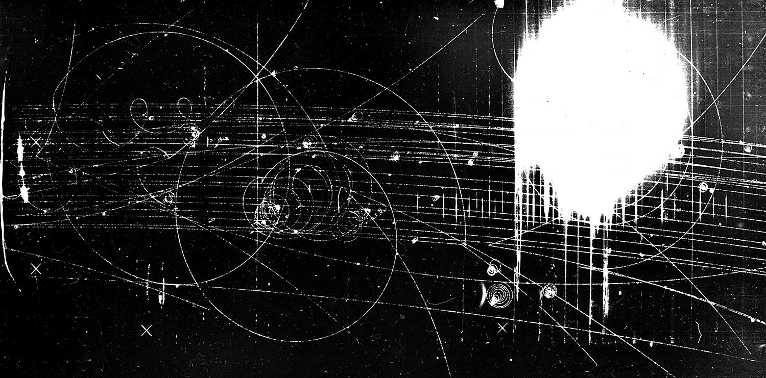 Stopy častíc v bublinovej komore naplnenej tekutým vodíkom. Vodík je v takzvanom prehriatom stave, v ktorom sa ľahko tvoria malé bublinky. Tie vznikajú najmä pozdĺž dráh prechádzajúcich častíc, čím robia tieto dráhy viditeľnými.