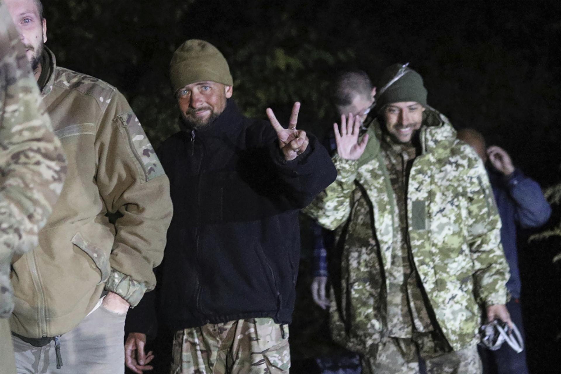 Ukrajinskí vojaci, ktorí boli prepustení pri výmene zajatcov medzi Ruskom a Ukrajinou, sa usmievajú v blízkosti ukrajinského Černigova, v stredu neskoro 21. septembra 2022
